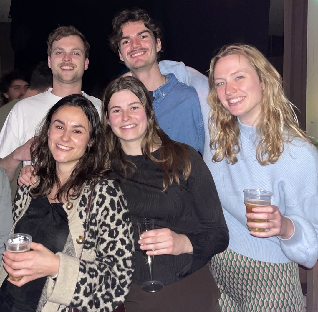 Konxhe with a group of friends laughing together at a social event