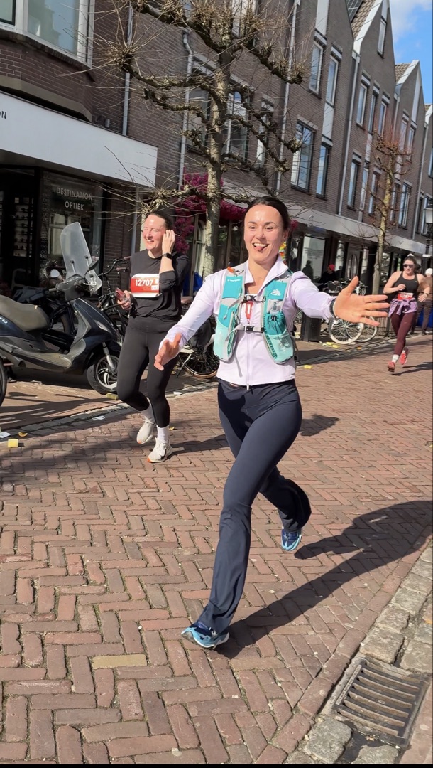 Konxhe running a road race through a Dutch city, arms wide open